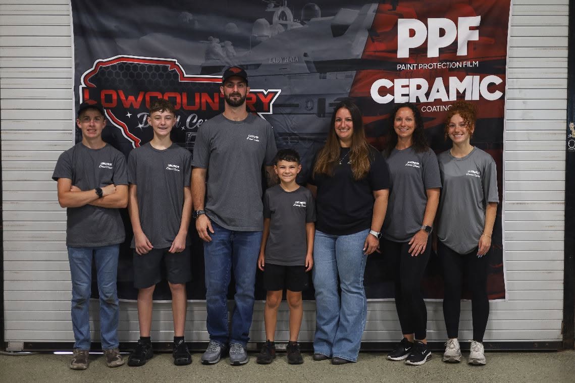The Lowcountry Detail Center team in front of the shop's PPF and window film banner